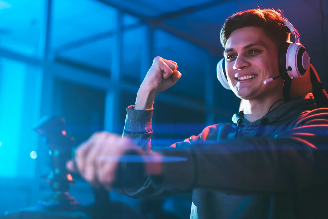 The gamer with headphones sitting and playing video games in the neon room stock photo