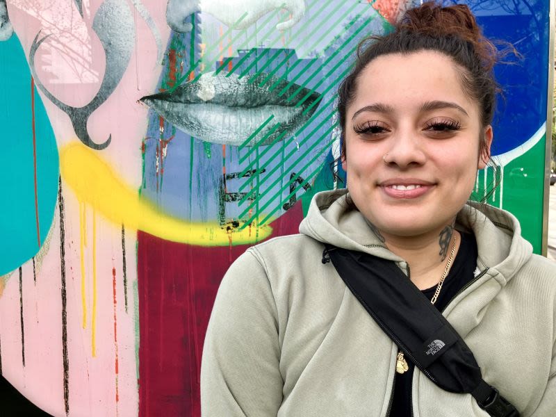 Portrait of Ingrid, standing in front of an art mural.