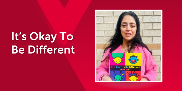 An educator smiles while holding It’s Okay to Be Different by Todd Parr. The colourful cover features cartoon faces in a grid. The image is overlaid on a red background with a faint Y M C A logo and the book title in text.