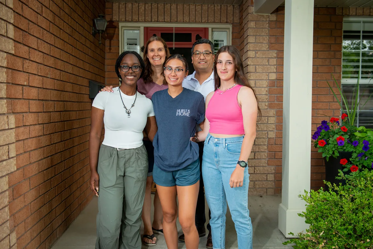 Three exchange students with their host family