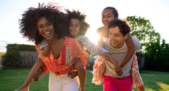 multicultural family of four plays in a park