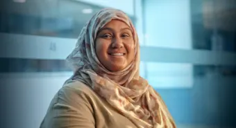 A close-up of a smiling immigrant services client.