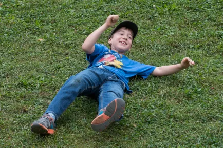 A little kid playing on grass.