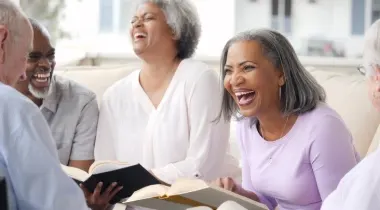 elders holding books and laughing