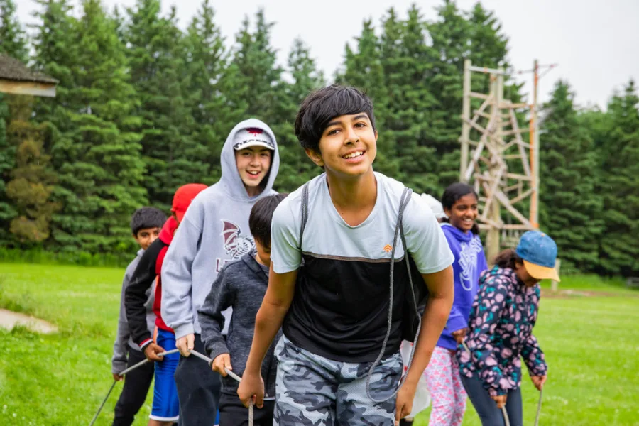 Teens working together outside to support high ropes