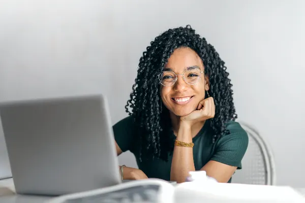 a black woman in smiling in front of a mirror