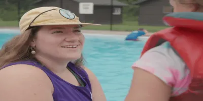 YMCA staff talking to a child next to the pool