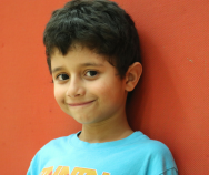 Young boy smiling between camp activities