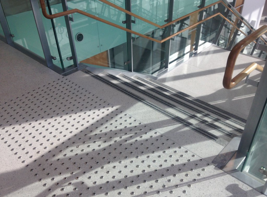 Tactile surface indicators near the staircase at Cooper Koo Family YMCA