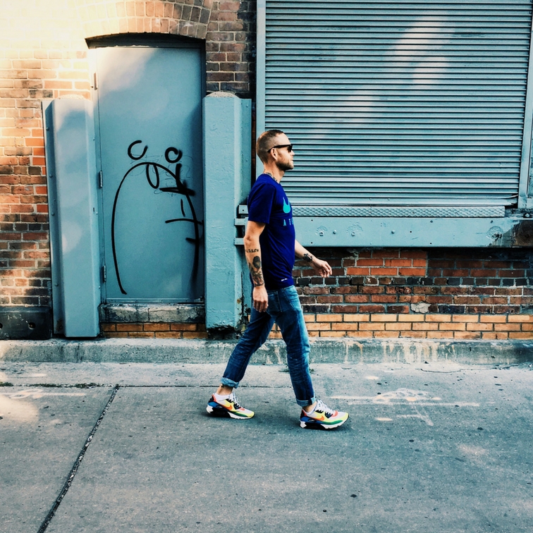 Ben walking on the street by a brick building