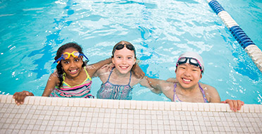 Campers posing by the swimming pool