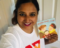 Y staff Smita holding a book wearing a Y Pride t-shirt